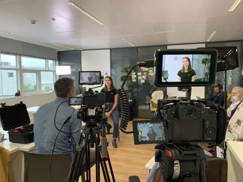 Tournage d'une interview en entreprise, caméra et retour vidéo au premier plan