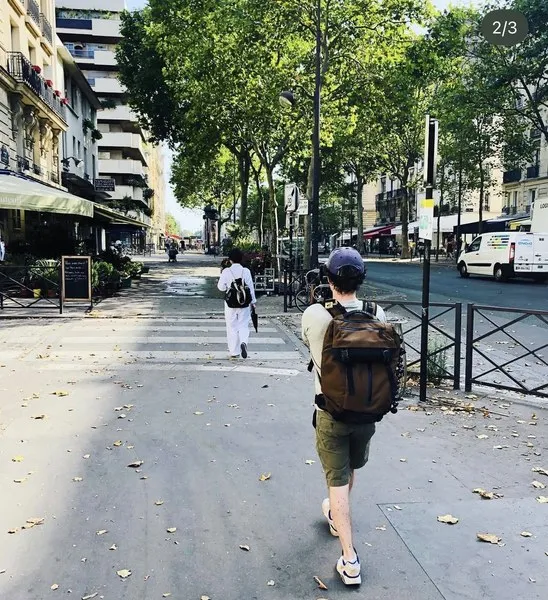 Vidéaste en repérage dans une rue, sac à dos de matériel