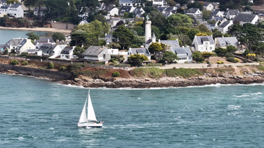 Port-Navalo et son phare filmés au drone à l’entrée du golfe du Morbihan, un voilier au premier plan